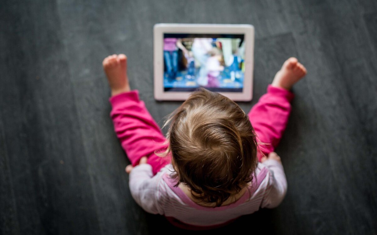 Toddler,Sitting,On,The,Floor,Looking,At,Tablet,Screen pantalla