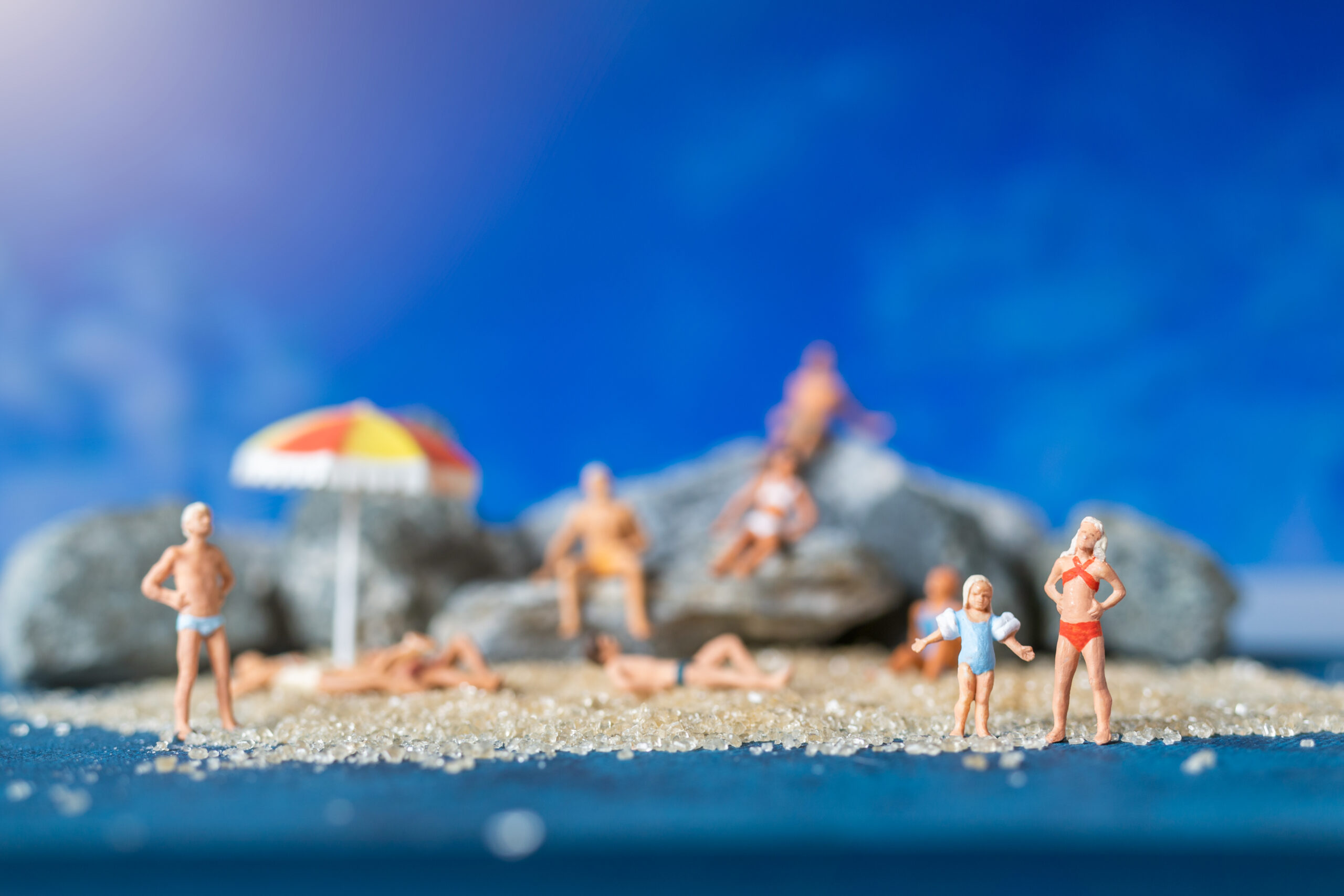 Miniature,People,Wearing,Swimsuit,Relaxing,On,The,Beach,With,Blue